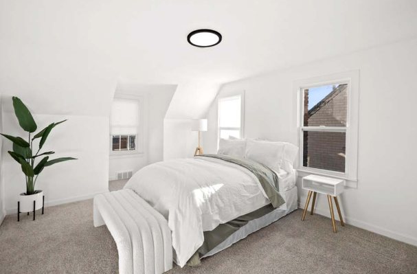 Upstairs dormer bedroom with carpet, white walls, and a flush-mount ceiling light